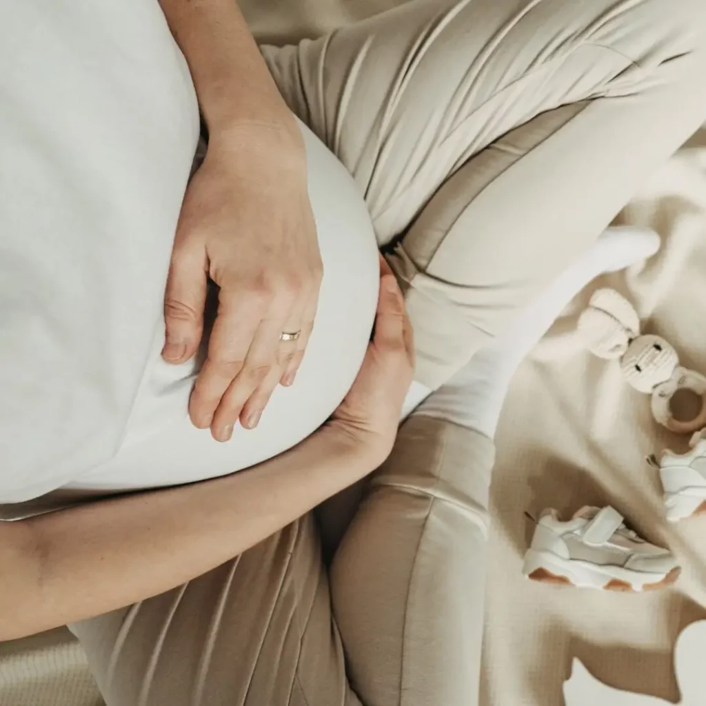 Pregnant woman enjoying future motherhood, preparing to child birth during pregnancy. Mother with wooden stuff for baby. Local eco children products, baby shower. Top view, copy space.